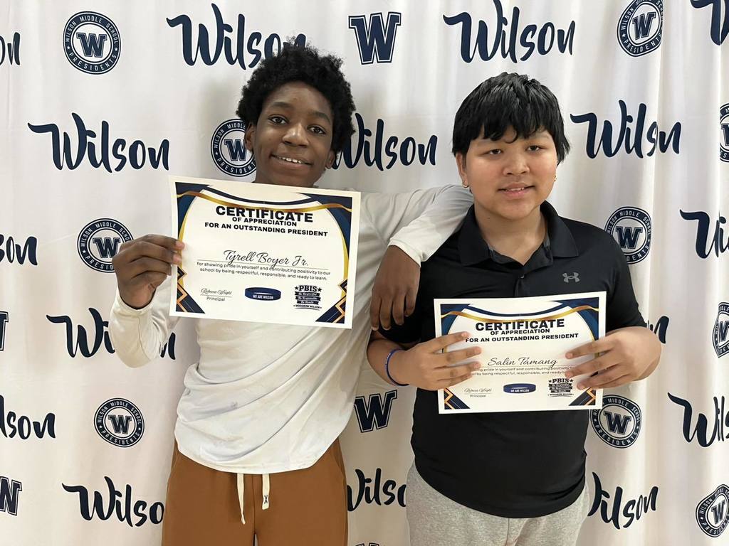 Two students holding their certificates. 