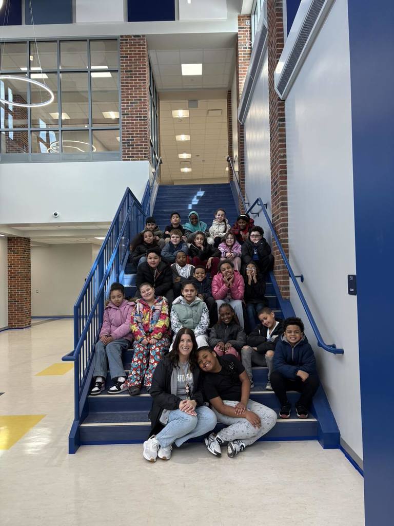 Students and their teacher sitting on the new stairs in the New Edison Elementary School. 