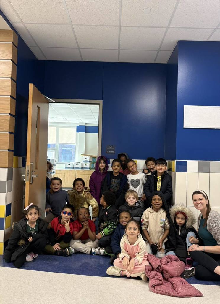Students and teacher sitting in front of their new classroom in the New Edison Elementary Building. 