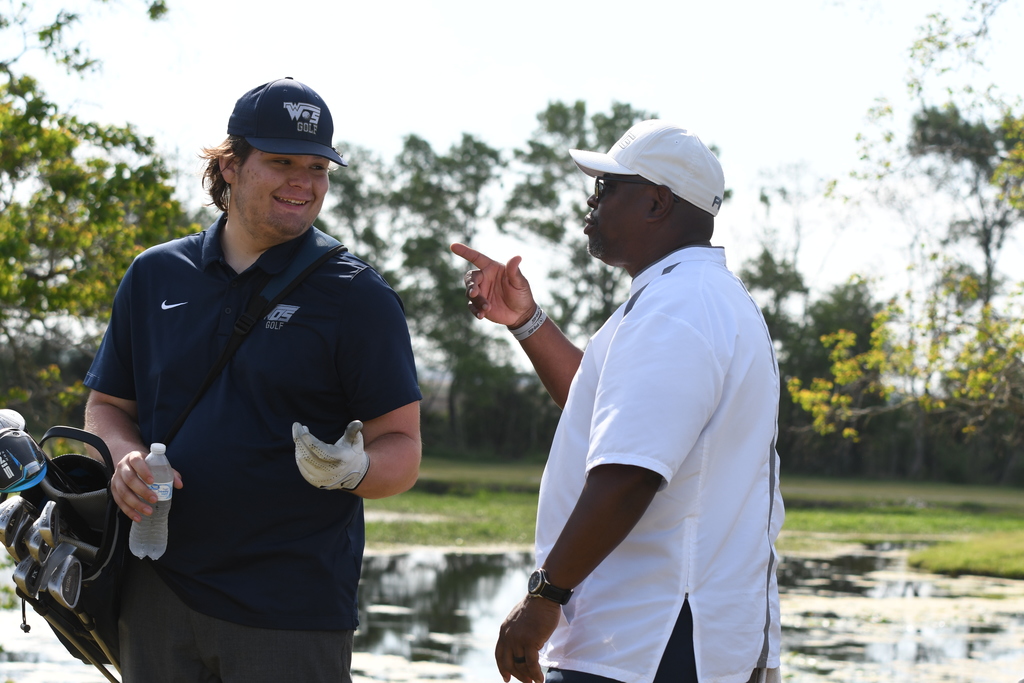 William Pugh and Coach Moffet talking between holes