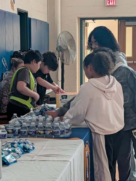 students are helping give out drinks and snacks to people attending the Family Movie Night. 