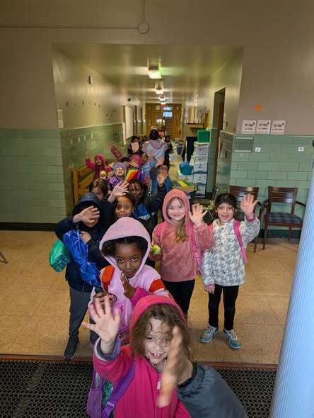 Students waving while they walk out of the old Edison Elementary School. 