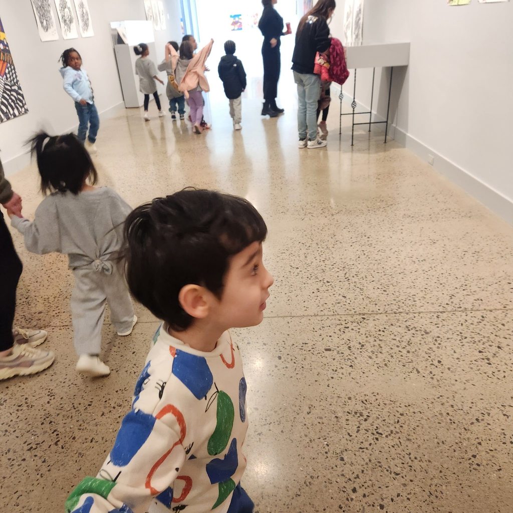 Kids walking in the halls of the Erie Art Museum. 