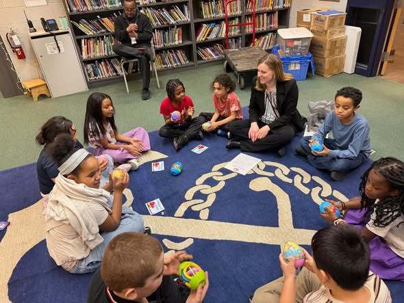Students playing  an egg swap dice game with McKinley Principal, Mrs. Bull.