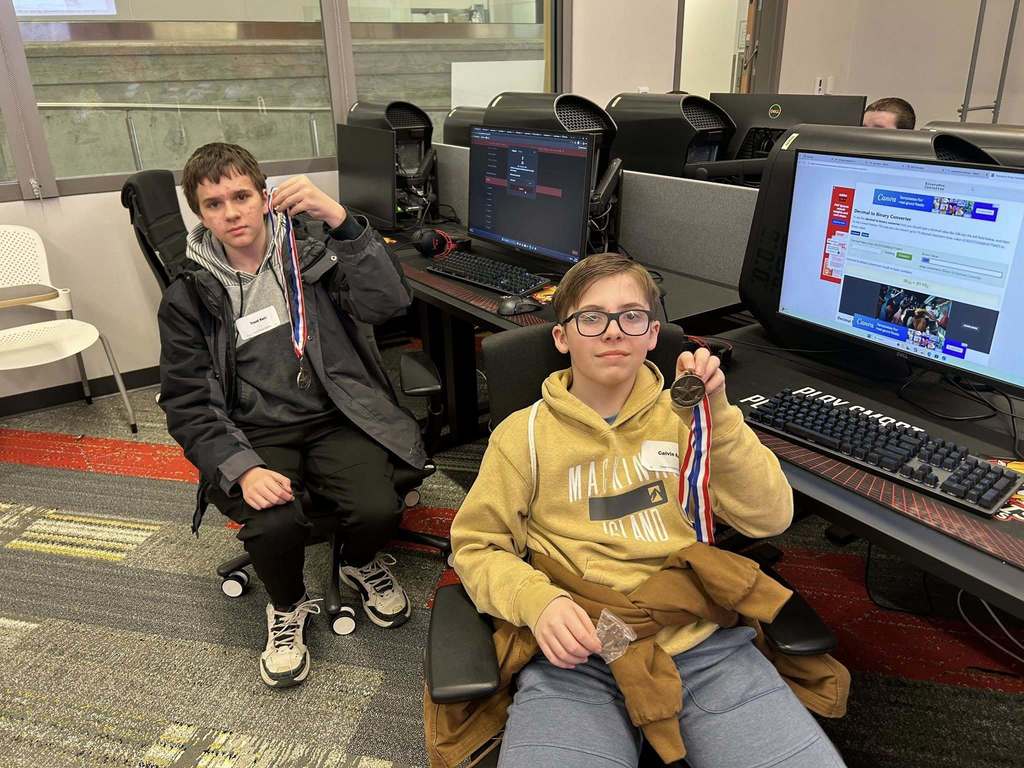Tri County Middle School students showing medals they earned from a competition at Cyber Security Day at Ferris State University.