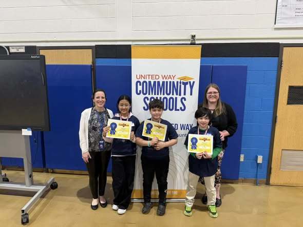 Students holding their certificates from Challenge 24 and staff standing next to them. 
