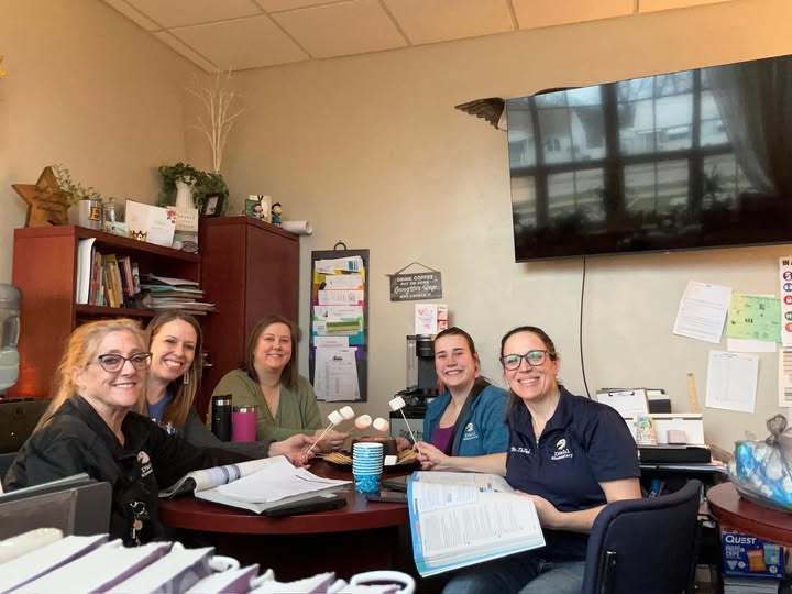 Staff at Diehl Elementary School working on math while they make s'mores in an office. 