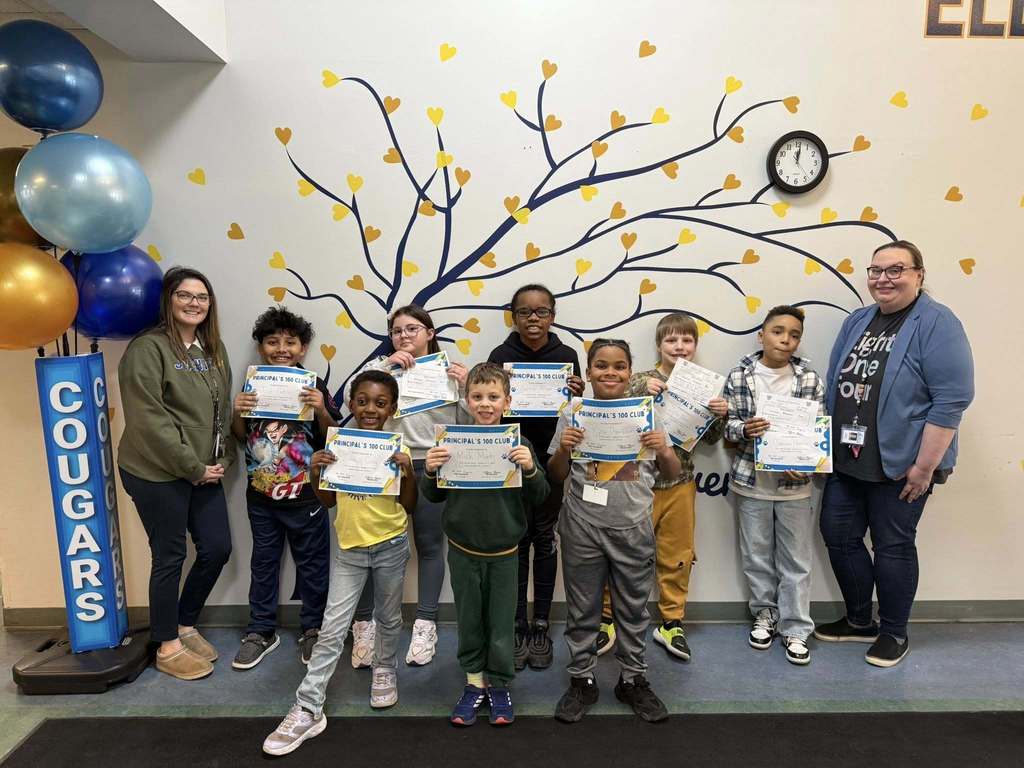 Students are holding their "Principal 100 Club" Awards and standing next to staff from JoAnna Connell.