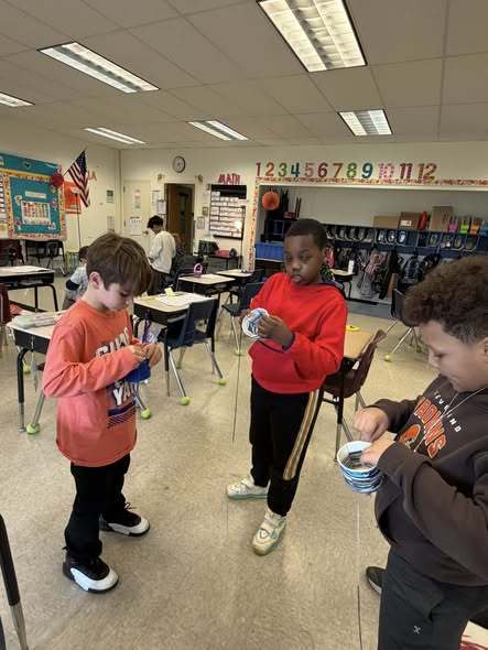 Students weaving baskets for easter in a classroom. 