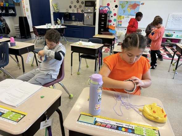 Students weaving baskets for easter in a classroom. 