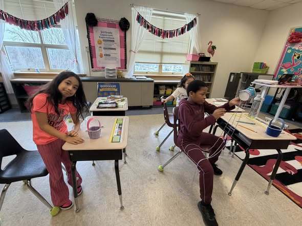 Students weaving baskets for easter in a classroom. 