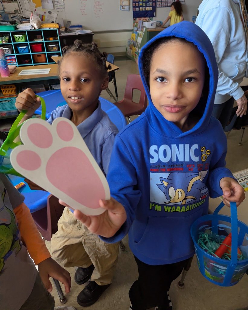 A student in a blue sonic hoodie is holding a bunny foot print and his basket. 