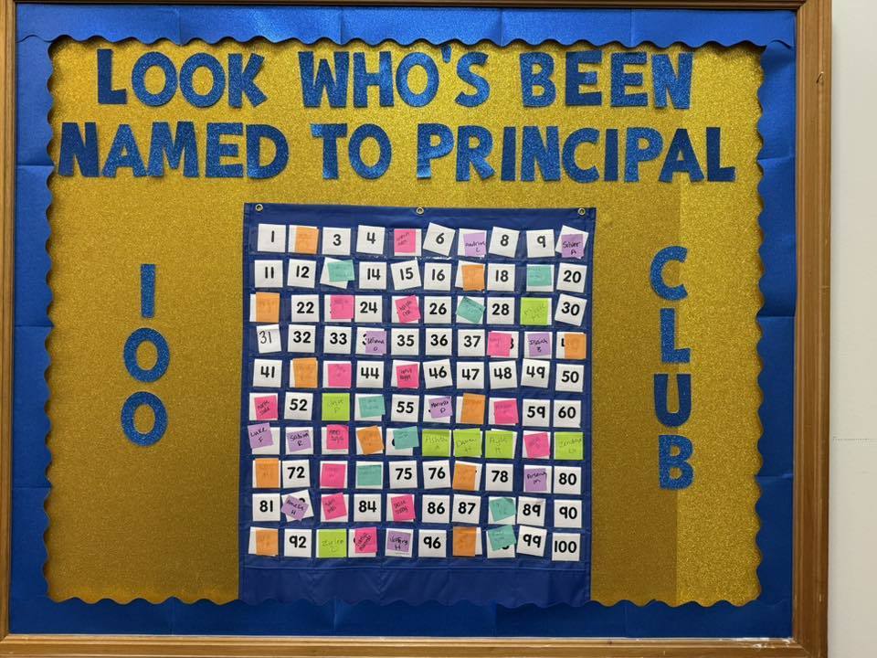 A board that says "Look who's been named to Principal 100 Club". 