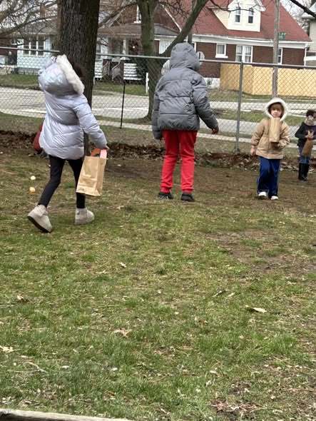 Students looking for easter eggs outside. 