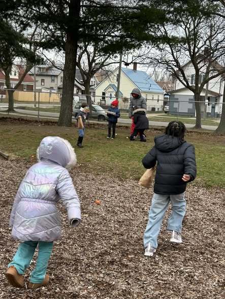 Students looking for easter eggs outside. 