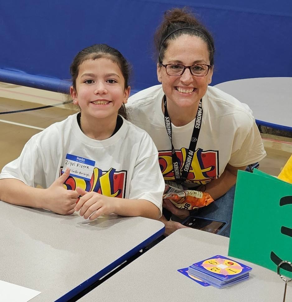 A student and adult posing for a picture. 