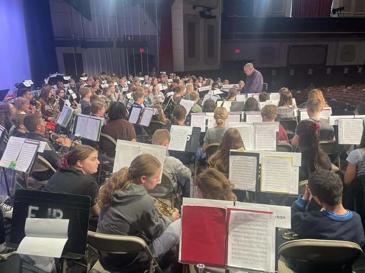 Students sitting in front of music sheets and they are ready to perform. 