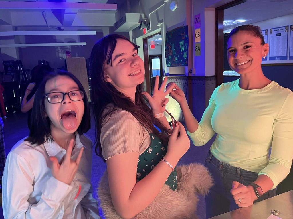 Students posing for a picture at their glow in the dark Q3 PBIS March Madness event.