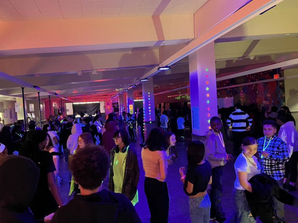 people talking to each other at the glow in the dark Q3 PBIS March Madness event.