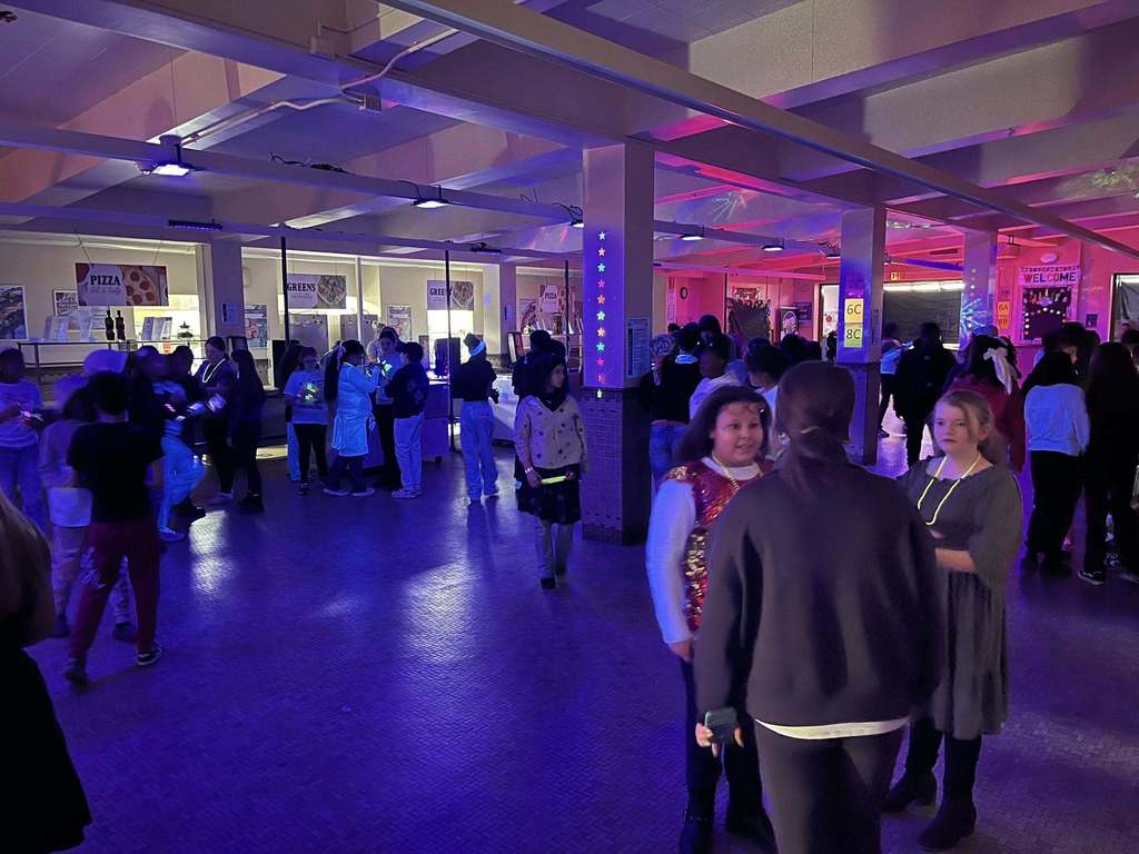 people talking to each other at the glow in the dark Q3 PBIS March Madness event.