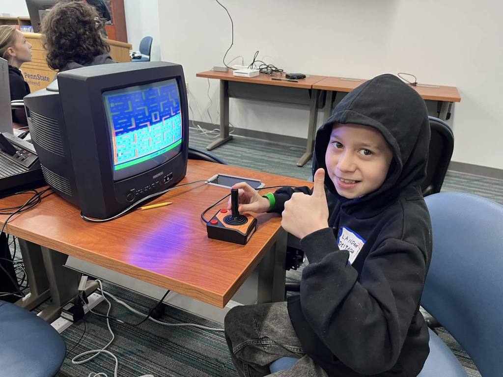 A student playing a game on a small old fashioned television. 