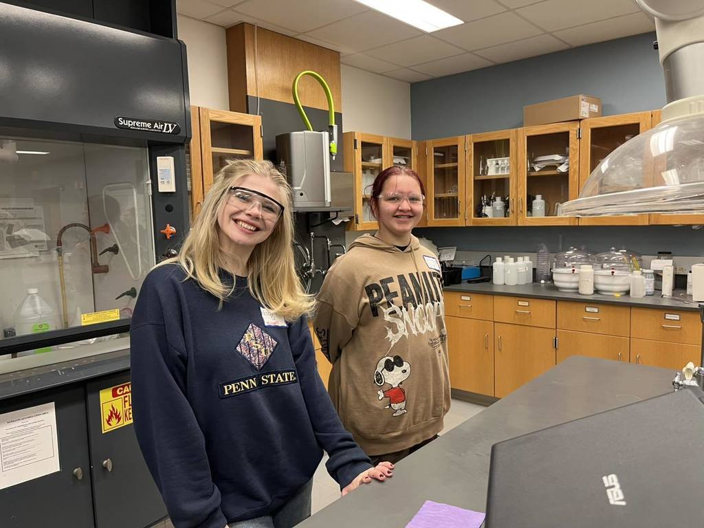 Students posing for a photo while they wear safety glasses. 