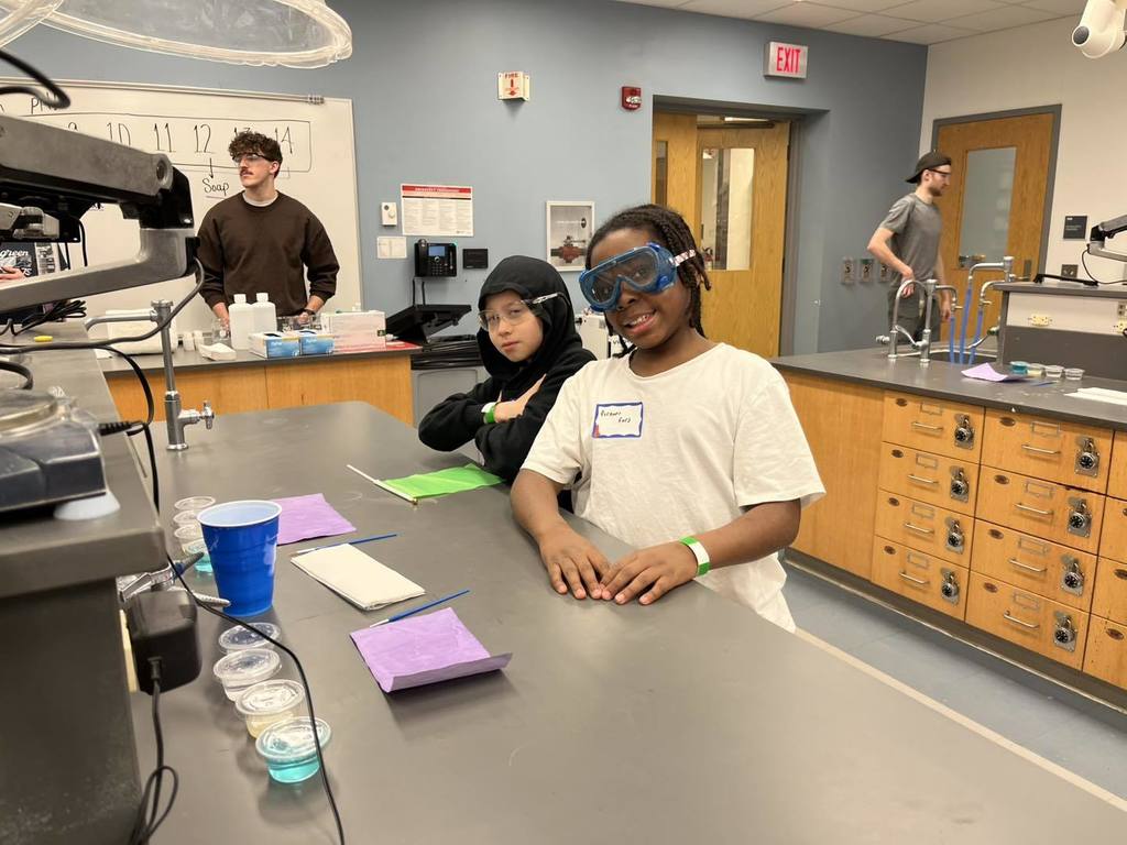 Students posing for a photo while they wear safety glasses. 