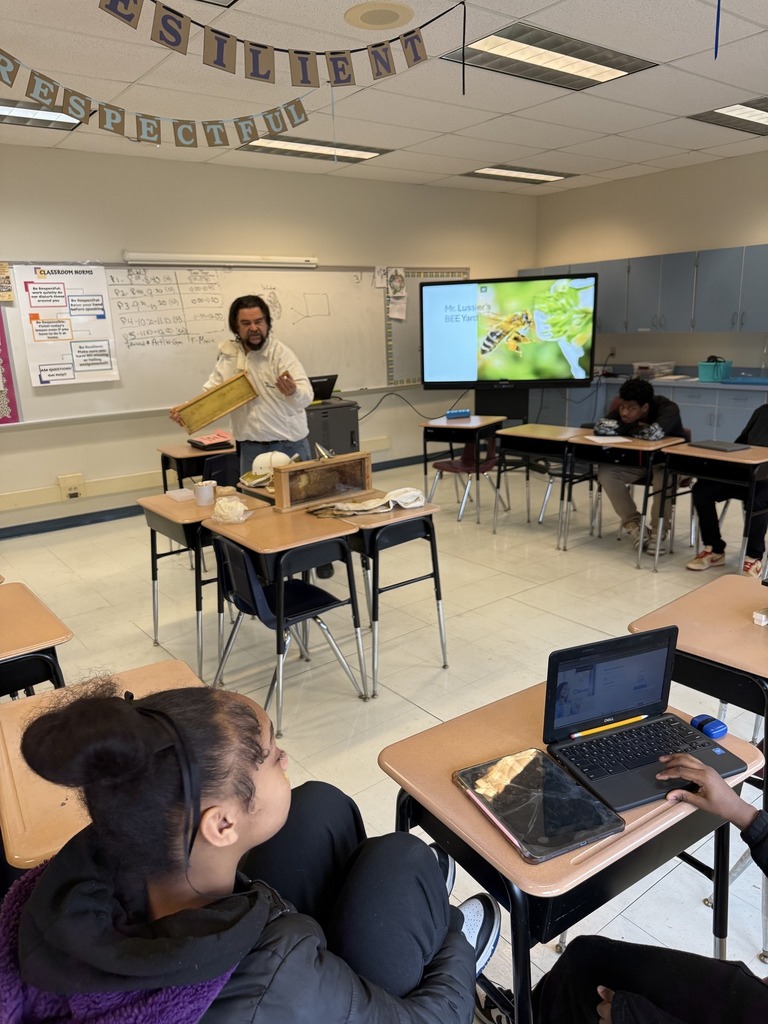 A teacher is speaking to students in a classroom. 