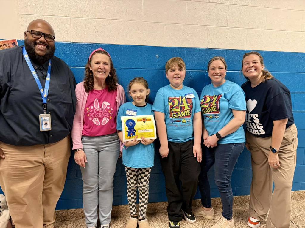 Staff posing next to students who participated in the Math 24 tournament.