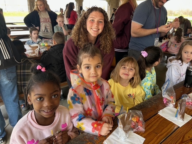 Key Club High school volunteer with kindergarteners and their eggs