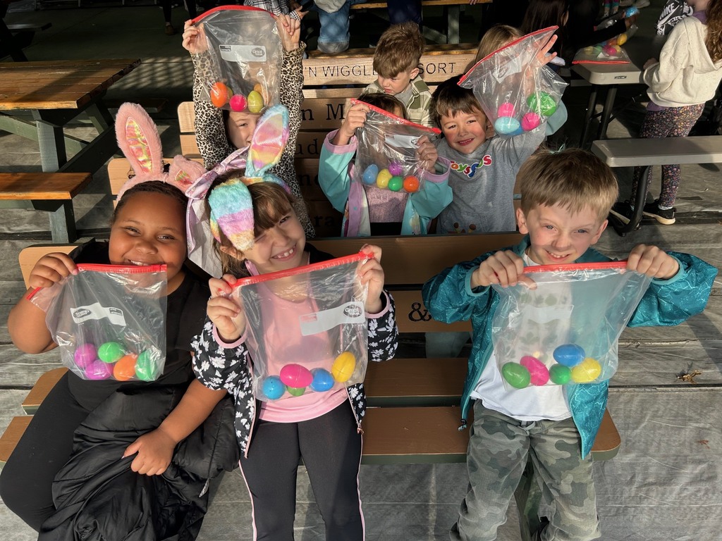 students holding up eggs