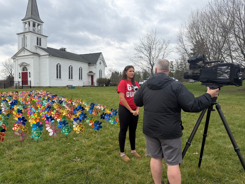 student being interviewed by channel 27 in front of pinwheel garden