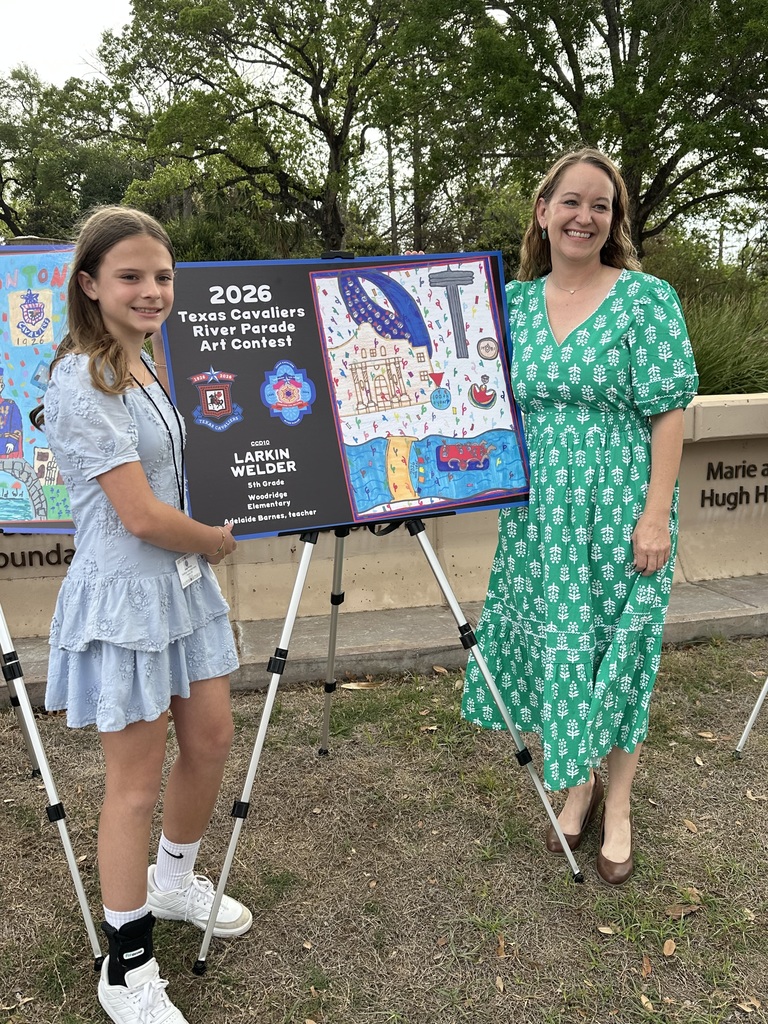 Student and teacher pose outside next to art on easel