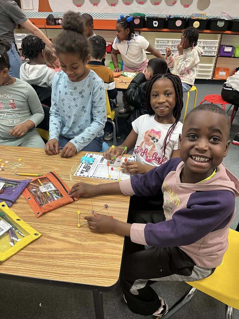 Kids posing as they make a house for easter peeps in class. 