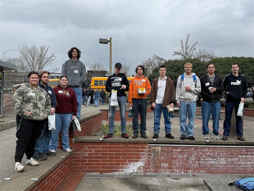 Klickitat students at Clark College standing on a low brick wall.