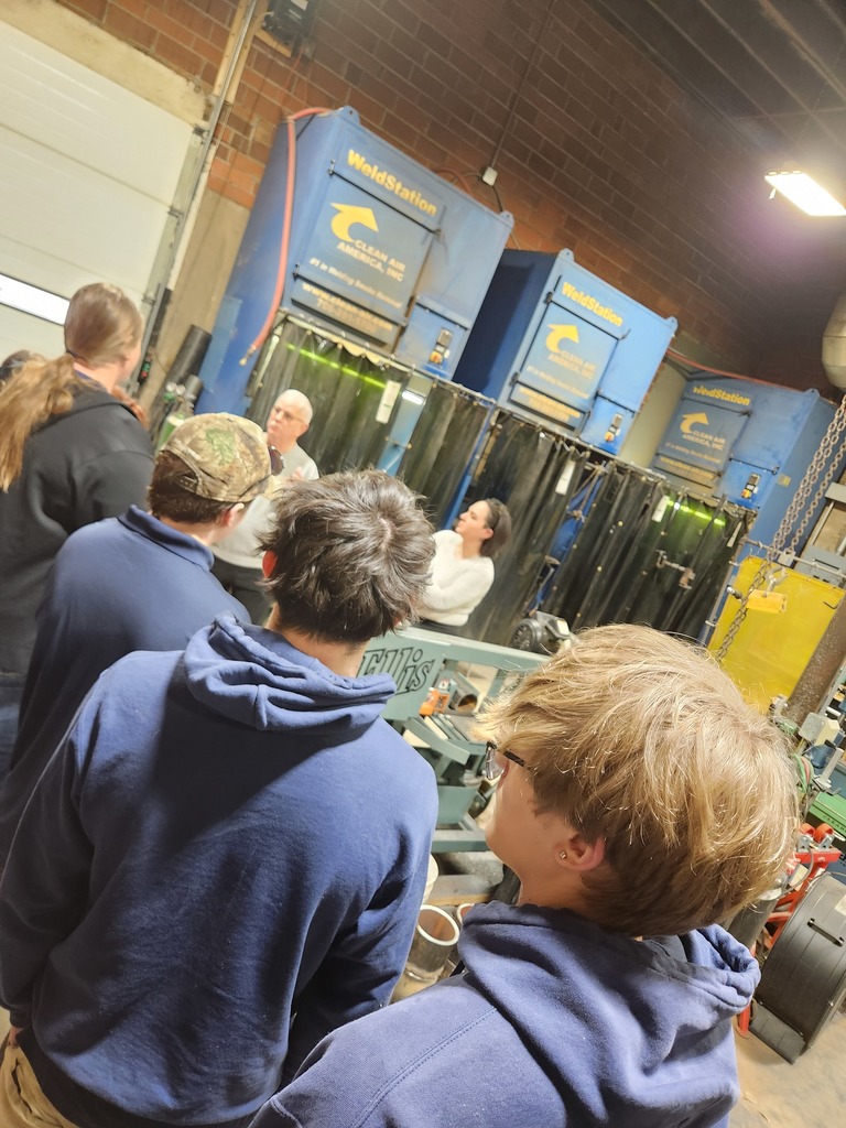 JAG students listening and learning about the welding facility while looking at the welding booths.