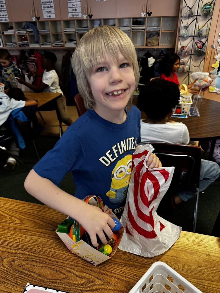 A kid in a blue minion shirt posing while holding one hand on his eggs and the other is holding a plastic bag. 
