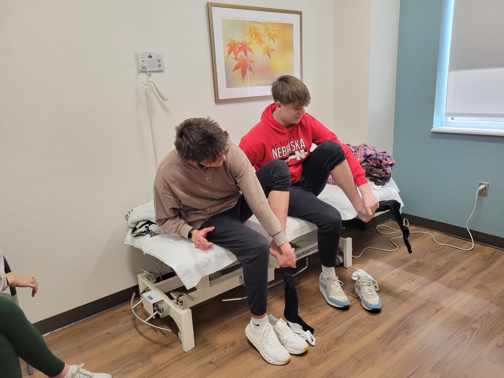 Students race to put socks on one handed to show how occupational therapists help people with injuries. 