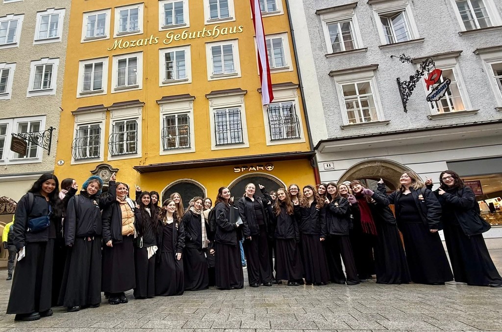 Choir students posing as a group in front of Mozarts Geburtshaus