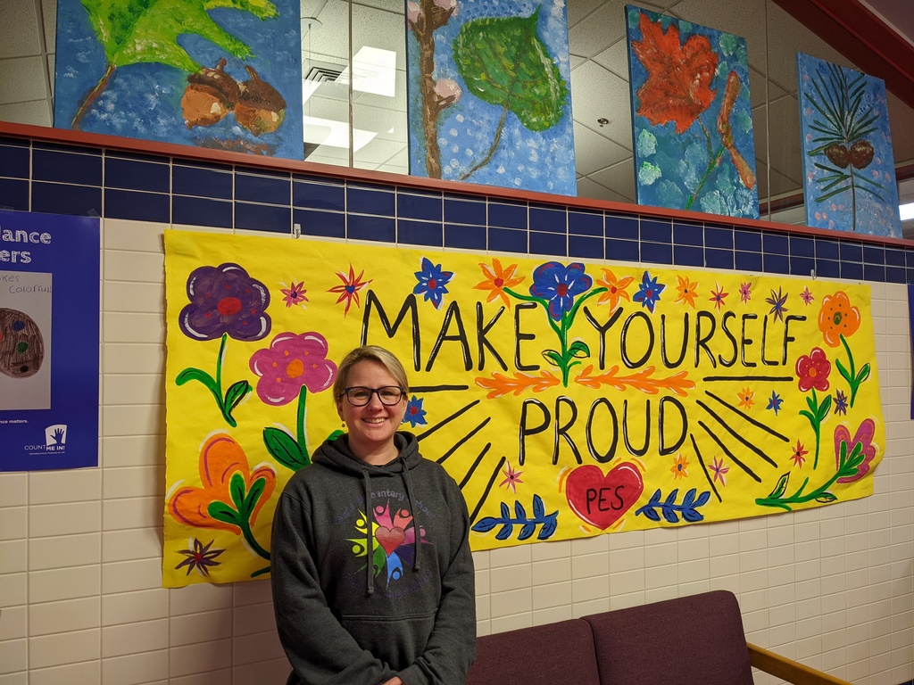 Ms. Armstrong standing in front of the banner she painted for this year.