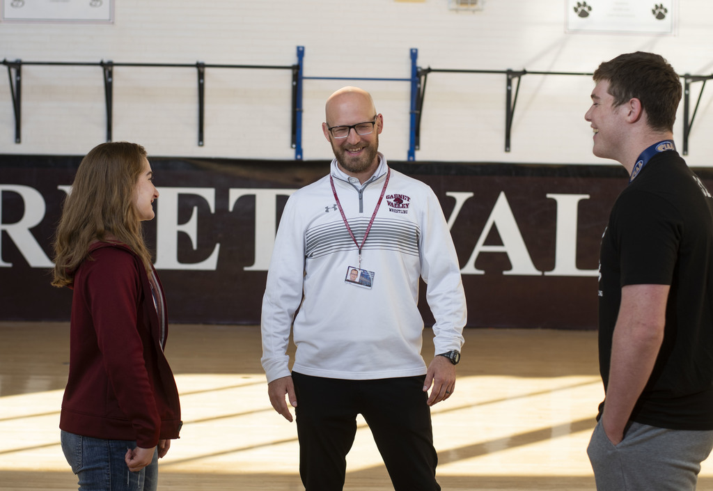 GVHS wrestling Coach, Mr. Tate, laughs as he talks with Paxton and Neve.