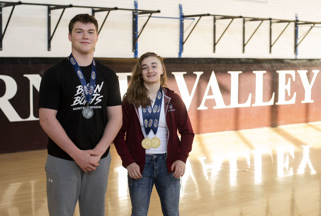 GVHS students, Neve O'Byrne and Paxton Hunt stand in the wrestling gym wearing their medals.