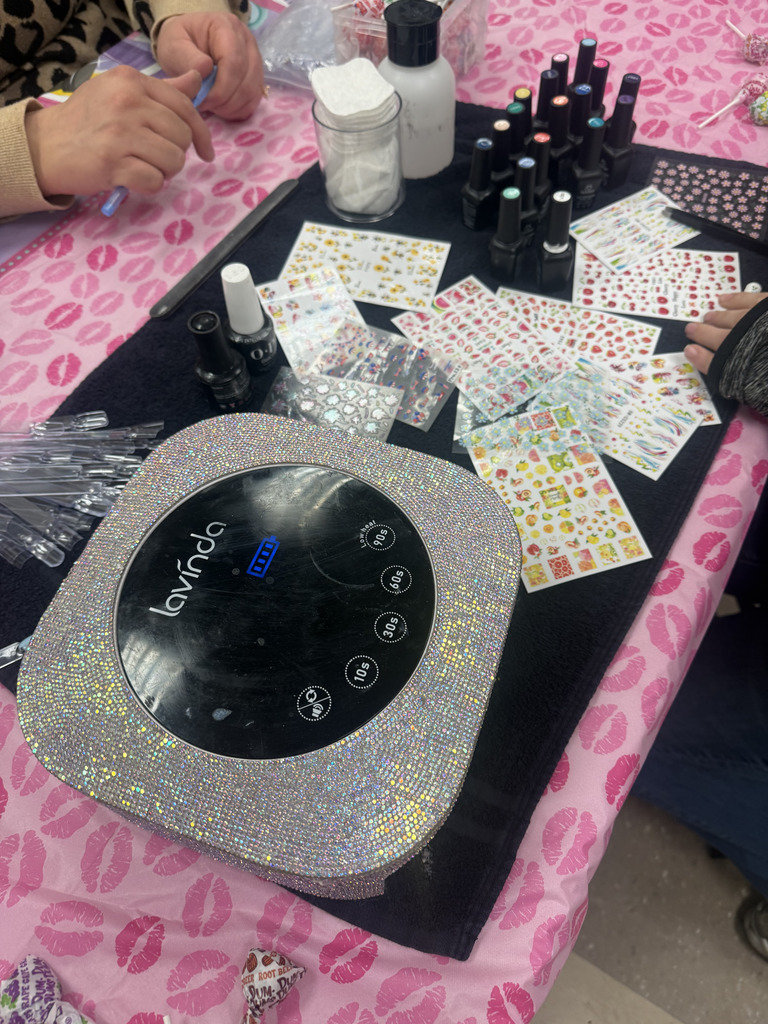 finger nail decorative stickers, nail polishes, and nail manicure tools on display on a job fair table