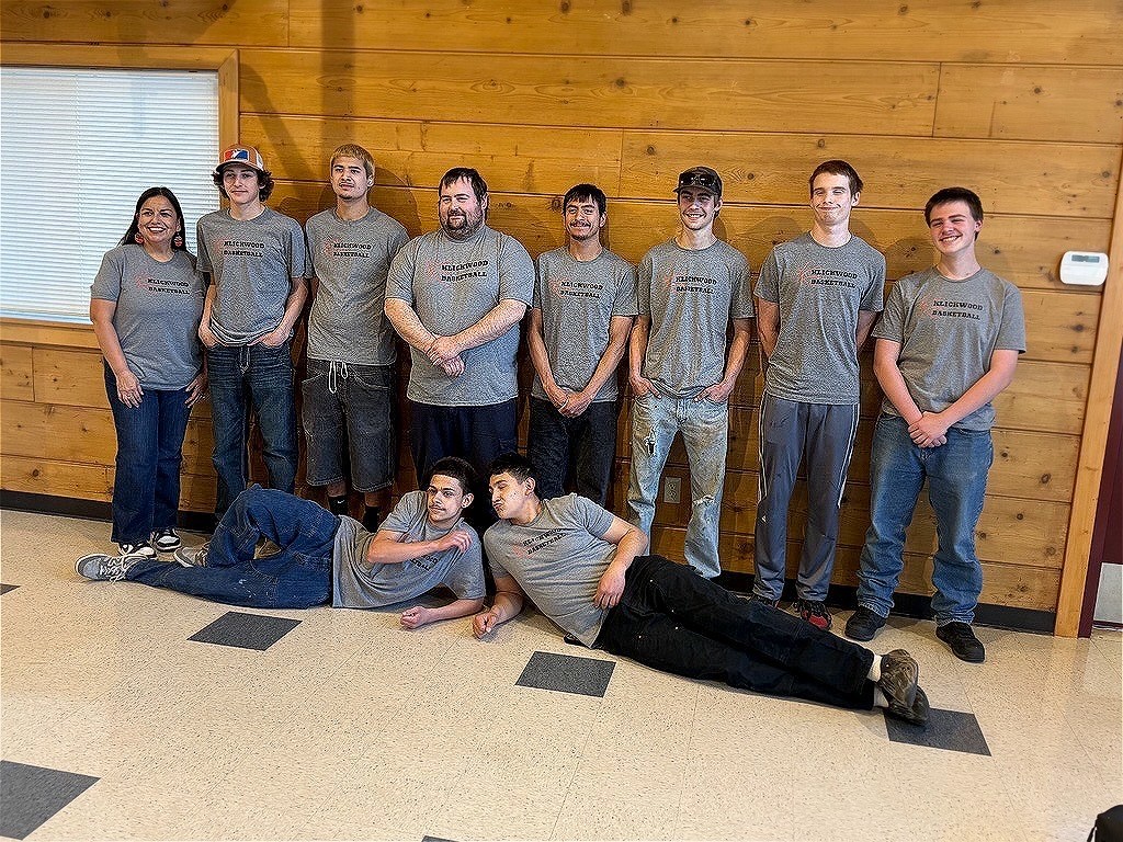 Basketball players posing. Two players are laying on the ground in front while the rest stand behind.