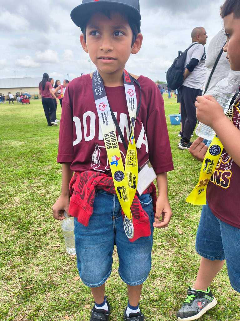 boy dark hari wth cap and medal