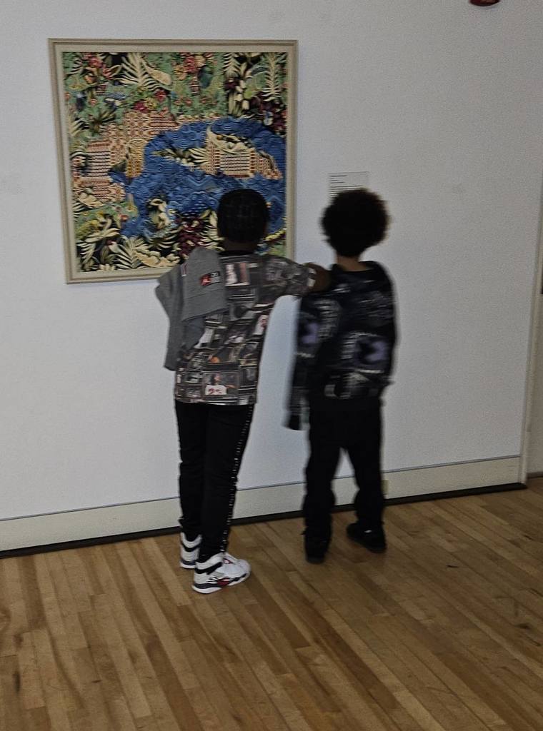 Two students looking at artwork in the Erie Art Museum. 
