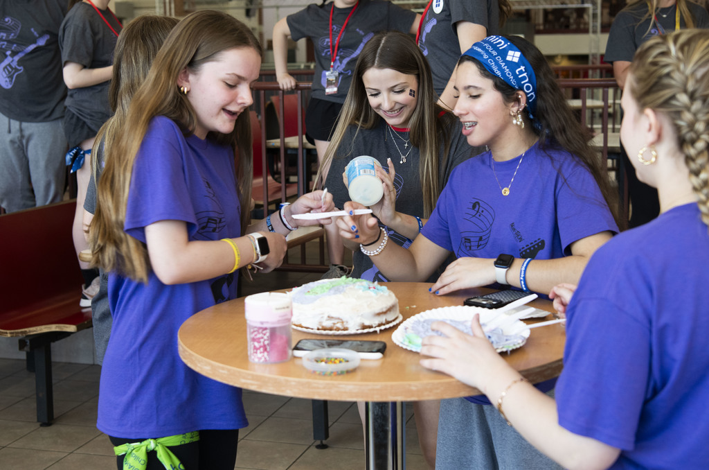 Students making a cake and laughing