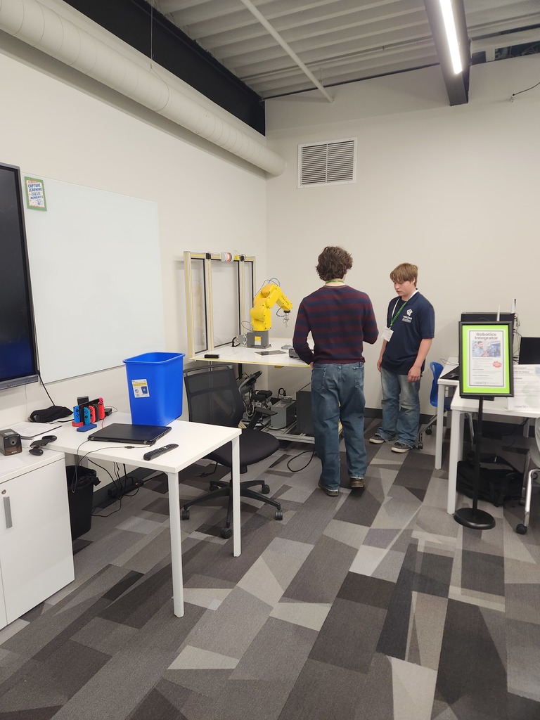 1 JAG students and 1 student helper working on the robotic arm