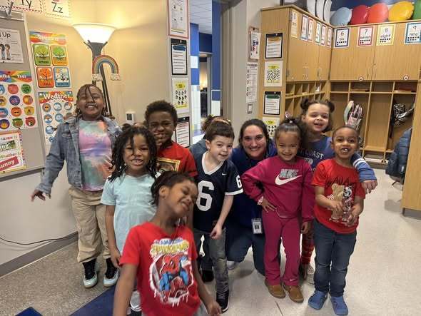 Students and teacher posing in their new classroom. 