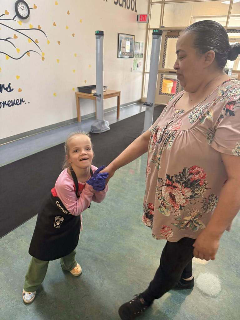A student holding a teachers hand. 